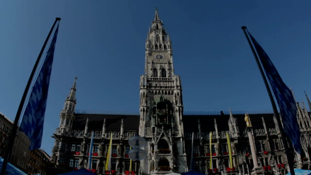 Clock-tower-im-Münchner-Marienplatz-umrahmt-von-bayerischen-flags