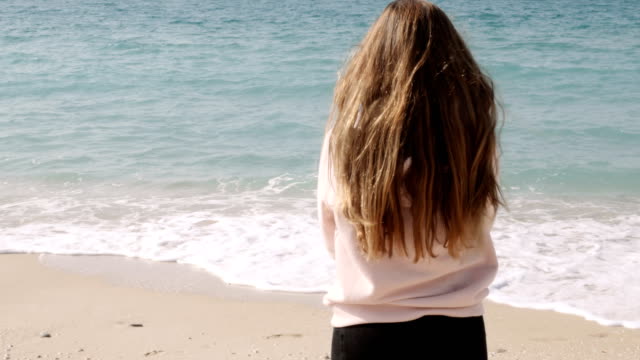 Chica-con-largo-cabello-pelirrojo-disfrutando-de-la-brisa-marina-contra-el-fondo-del-paisaje-marino.-Brisa-del-mar-jugando-con-el-pelo.