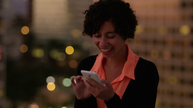 Woman-using-phone-at-night-in-city