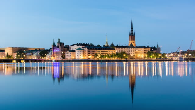Stockholm-city-summer-night-4K-Time-Lapse.-Riddarholmen-island-cityscape,-reflections-in-the-water