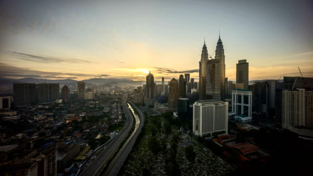 Timelapse-4k-Aufnahmen-von-einem-wunderschönen-Sonnenaufgang-Nacht-zum-Tag-der-Blick-auf-die-Stadt-Kuala-Lumpur-vom-Dach-eines-Gebäudes-Sonnenuntergang-Tag-und-Nacht-von-Kuala-Lumpur-City-Blick-vom-Dach-eines-Gebäudes-mit-sich-bewegenden-Fahrzeug-und-Wolken.