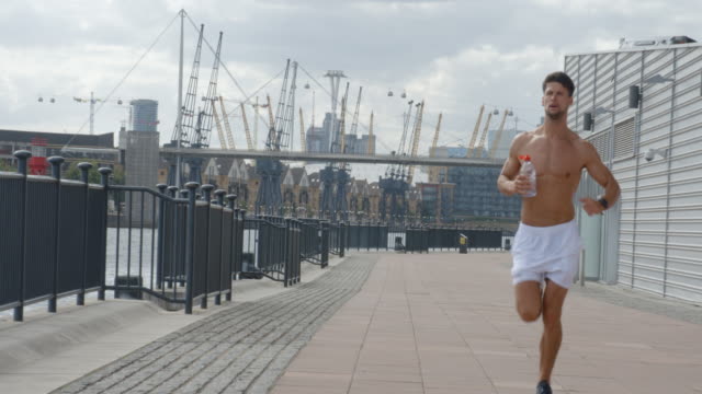 Un-joven-corriendo-aunque-Londres-con-ciudad-de-Londres-detrás-de-él.