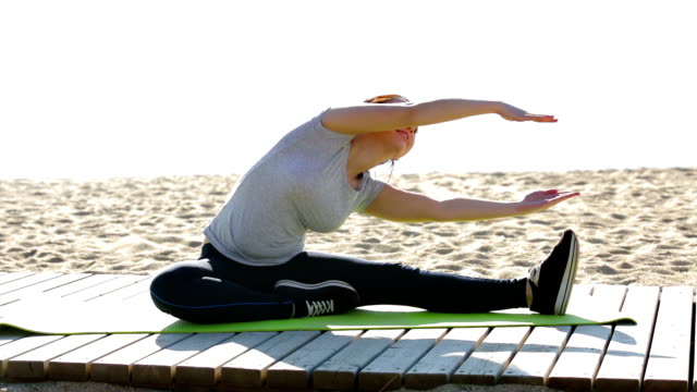 slim-woman-doing-exercises-on-beach