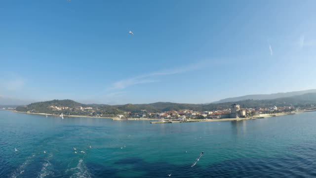 View-of-seagull-birds-fly-with-Phospfori-tower-in-Ouranopolis,-Athos-Peninsula,-Mount-Athos,-Chalkidiki,-Greece-at-background