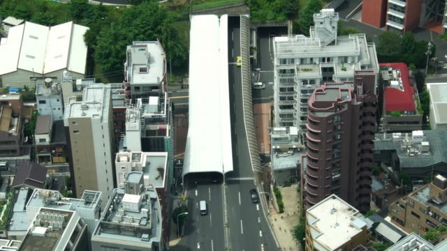Modern-Tokyo-tunnel-busy-street-with-cars-between-the-buildings-seen-from-aerial-view-in-Japan