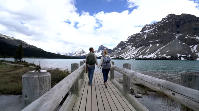 Young-couple-enjoying-nature-at-mountain-lake,-Canada