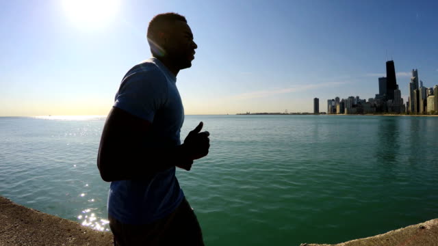Young-Ethnic-male-running-along-Chicago-city-shoreline