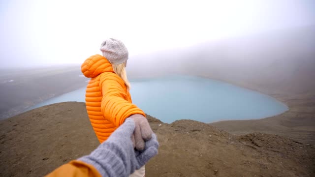 Follow-me-to-the-crater-lake,-girlfriend-leading-man-to-volcanic-crater-in-Iceland-People-travel-concept-4K-video