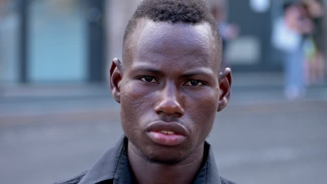 Porträt-von-stolzer-zuversichtlich-jungen-afrikanischen-Mann-starrte-auf-Kamera-Outdoor-Nahaufnahme