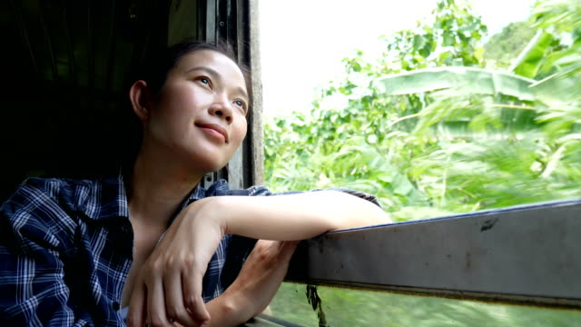 4-viajes-de-mujer-asiática-de-K.-en-tren-mirando-por-la-ventana-del-tren-en-ferrocarril-tren-Inicio-en-Bangkok-ir-a-Kanchanaburi-en-Tailandia.-disfrutar-de-transporte-por-tren-vintage