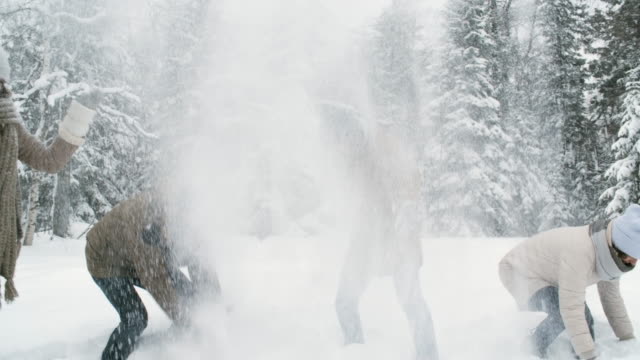 Amigos-felices-jugando-con-nieve-en-el-bosque