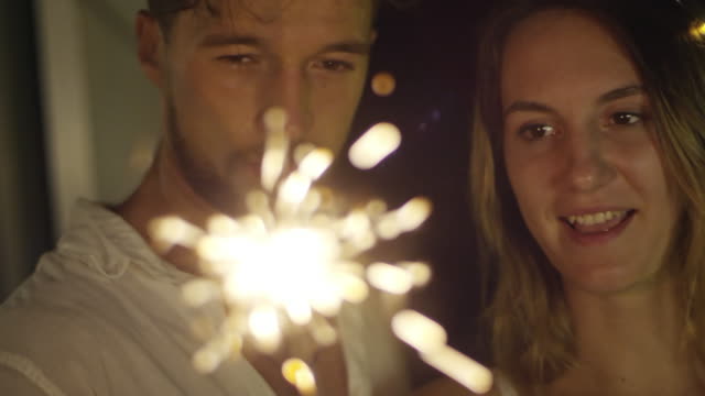 Caucasian-Couple-Looking-at-Sparkler-Flames