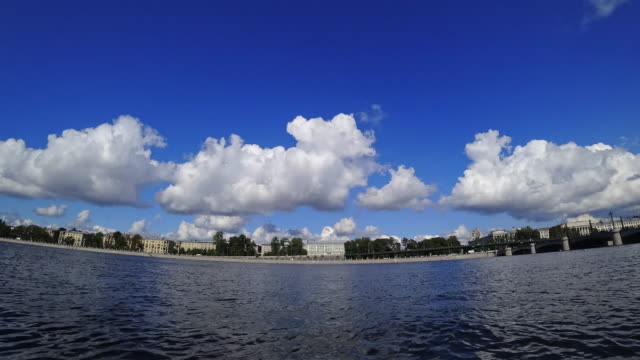 Time-lapse-of-rolling-cumulus-clouds-on-a-sunny-day.-Embankment-of-a-Neva-river-in-St.-Petersburg,-Russia.