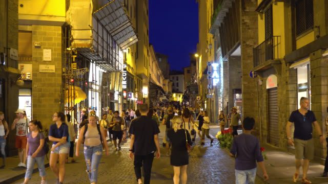 Florenz,-Toskana,-Italien.-Menschen-Fuß-entlang-der-beleuchteten-Via-Via-Por-Santa-Maria-in-der-Nacht