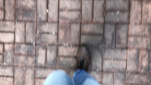 POV-de-persona-caminando-sobre-asfalto-con-botas-del-viajero.-Punto-de-vista-perspectiva