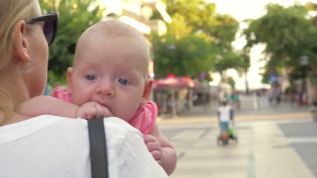 Baby-having-outdoor-walk-in-mothers-arms