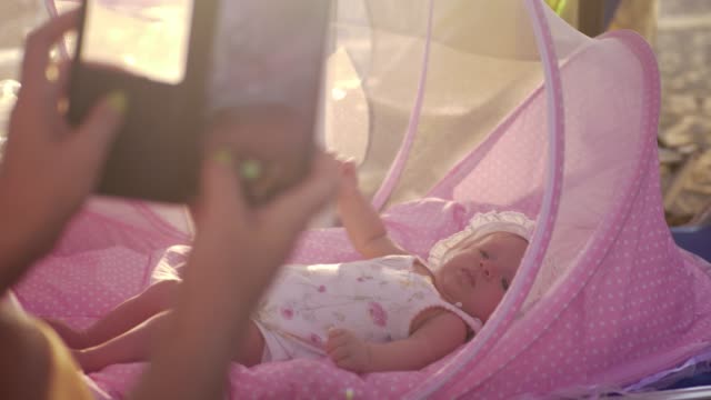 Mamá-con-móvil-toma-foto-de-bebé-en-el-Moisés-al-aire-libre
