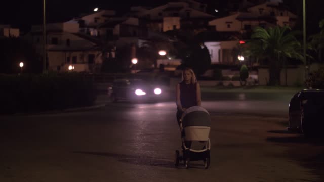 Mother-with-baby-having-late-walk-in-the-street