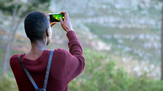 Woman-clicking-photos-with-mobile-phone-at-countryside-4k