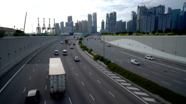 Tráfico-en-el-tráfico-en-carretera-y-Singapur-con-rascacielos-en-fondo