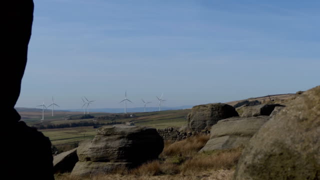 Windkraftanlagen-durch-Spalt-zwischen-Steinen