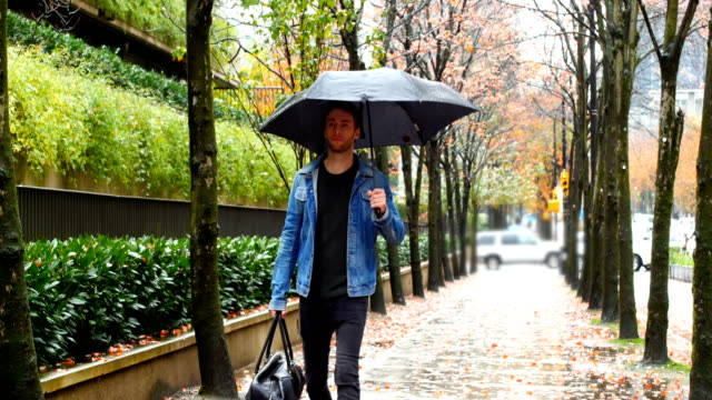 Mann-hält-einen-Regenschirm-und-gehen-auf-der-Straße