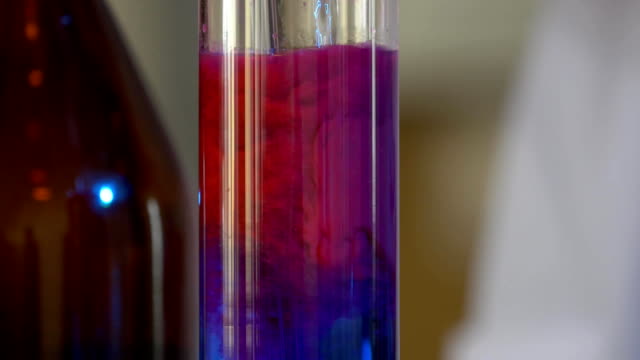 Científico-vierte-productos-químicos-patrón-azul-en-frasco.-concepto-de-salud-y-médico.-Científico-son-algunas-actividades-en-la-ciencia-experimental-como-la-mezcla-de-productos-químicos