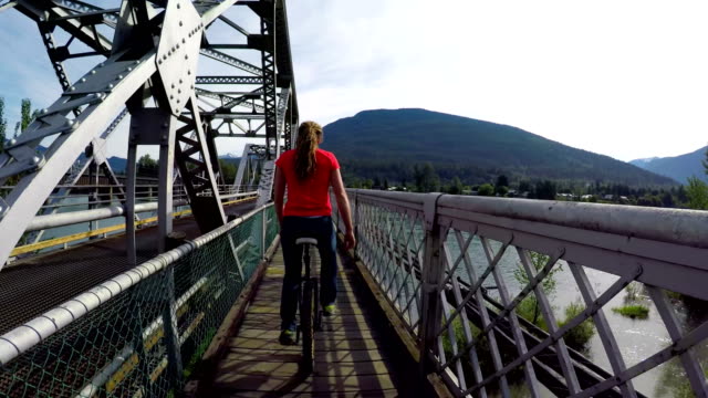 Woman-riding-unicycle-on-the-bridge-4k