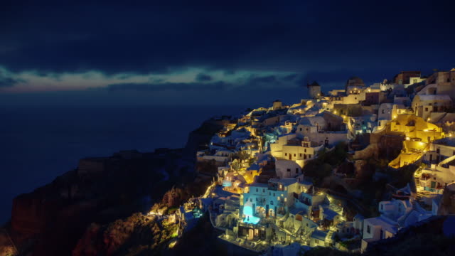 sunset-illuminated-santorini-island-oia-town-bay-hill-panorama-4k-time-lapse-greece