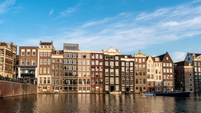 Amsterdam-Stadt-Skyline-Zeitraffer-am-Damrak-Kanal-Wasser,-Amsterdam,-Niederlande-4K-Zeitraffer