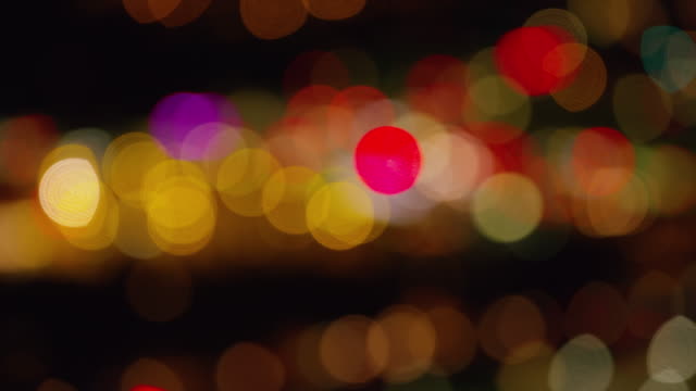 Aerial-shot-goes-out-of-focus-to-make-blurred-lights-at-night