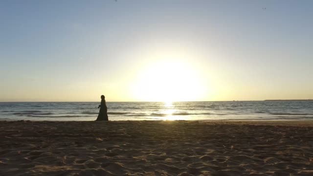 Sonnenuntergang-am-Strand-mit-Menschen-zu-Fuß-durch-Marokko