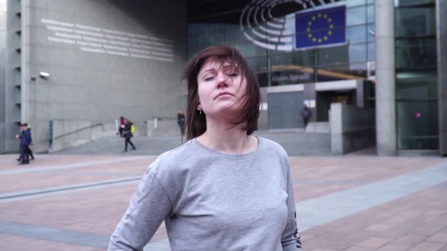 Tourist-Dame-geht-und-schaut-Attraktionen-in-der-Nähe-des-Europäischen-Parlaments-in-Brüssel.-Belgien.-langsame-motion.dolly-Zoom-Effekt