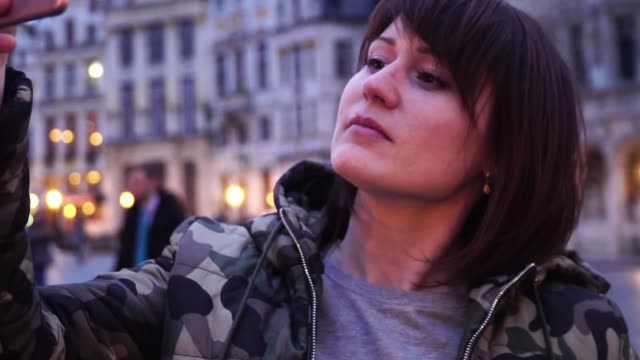 Lady-tourist-takes-pictures-on-Grand-Place-in-Brussels,-Belgium.slow-motion.-dolly-zoom-effect