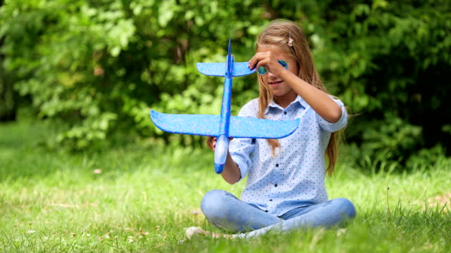 Neun-jährige-Mädchen-spielen-mit-Spielzeugflugzeug