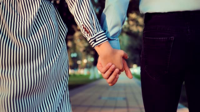 Romantische-junge-Menschen-und-Liebe,-Mann-und-Frau-zu-Fuß-und-Hand-in-Hand-im-Stadtpark