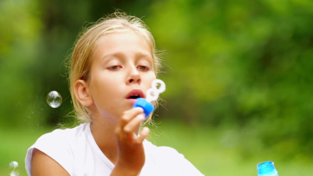 Kleines-Mädchen-spielt-mit-Seifenblasen-im-Freien.-Slow-Motion.