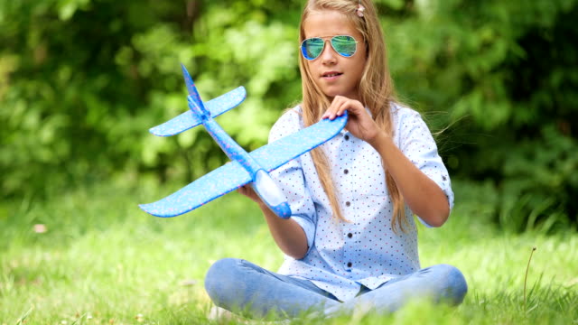Nine-year-old-girl-playing-with-toy-airplane