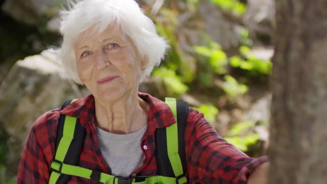 Mujer-Senior-feliz-senderismo-en-el-bosque