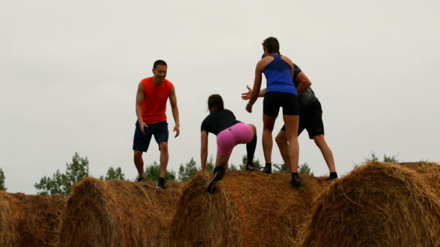 Joggers-helping-his-friend-while-jumping-from-hay-bales-4k