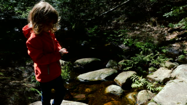 Child-in-Front-of-a-Crystal-Clear-Stream-in-a-Forest