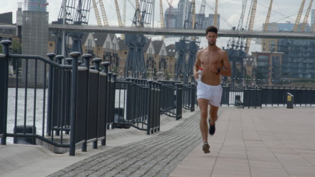 Un-joven-corriendo-aunque-Londres-con-ciudad-de-Londres-detrás-de-él.