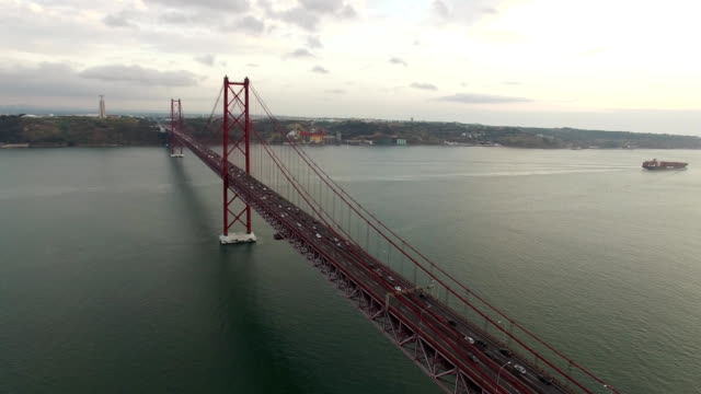 Bridge-Ponte-25-de-Abril-over-the-Tagus-river-in-Lisbon,-Portugal-at-evening-aerial-view