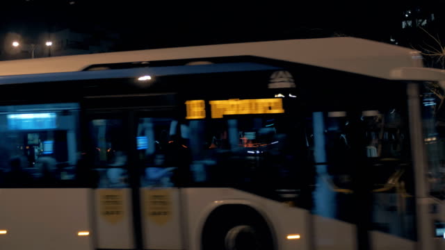 Bus-traveling-in-night-city-of-Tel-Aviv,-Israel