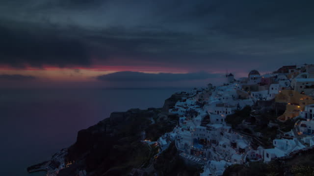 Sonnenuntergang-Himmel-berühmte-Santorini-Insel-Oia-Stadt-Hügel-Panorama-4-k-Zeit-hinfällig,-Griechenland