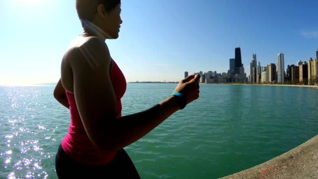 Ethnic-female-running-in-sportswear-by-Chicago-shoreline