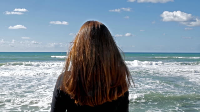 Girl-with-long-red-hair-in-the-beach,-sea-breeze-play-with-hair,-daytime-shot.