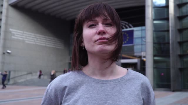Tourist-Dame-geht-und-schaut-Attraktionen-in-der-Nähe-des-Europäischen-Parlaments-in-Brüssel.-Belgien.-langsame-motion.dolly-Zoom-Effekt