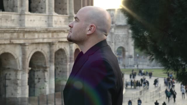 relaxed-bald-man-contemplating-the-colosseum-in-Rome