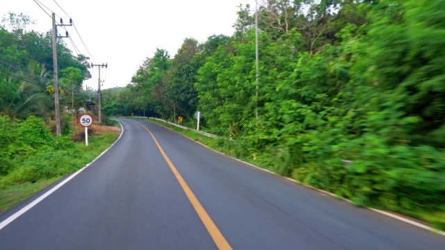 Cabalgando-sobre-una-carretera-asfaltada-en-un-país-tropical.-palmeras-a-lo-largo-de-la-carretera,-selva